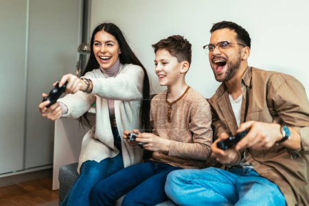 Foto de Familia feliz jugando videojuegos en casa y divirtiéndose juntos. - Imagen libre de derechos