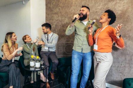 Téléchargez les photos : Les gens d'affaires faisant l'exercice de formation d'équipe pendant le séminaire de team building chantant karaoké et boire. - en image libre de droit