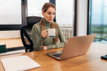 Téléchargez les photos : Portrait d'une femme prospère, femme d'affaires travaillant dans un bureau moderne sur ordinateur portable. - en image libre de droit