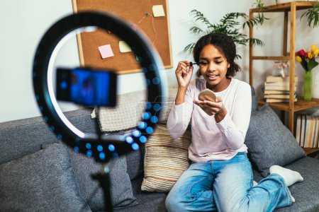 Foto de Teenager Girl Making A Video Blog On A Smartphone At Her Home. Beauty, makeup - Imagen libre de derechos