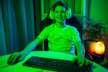 Téléchargez les photos : Garçon jouer jeu vidéo en ligne sur son ordinateur personnel. - en image libre de droit