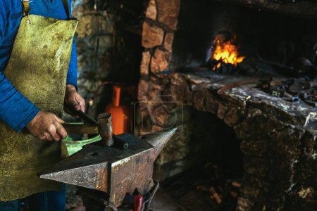 Téléchargez les photos : Forgeron forgeant manuellement le métal fondu sur l'enclume en forge avec des feux d'artifice, fermer - en image libre de droit