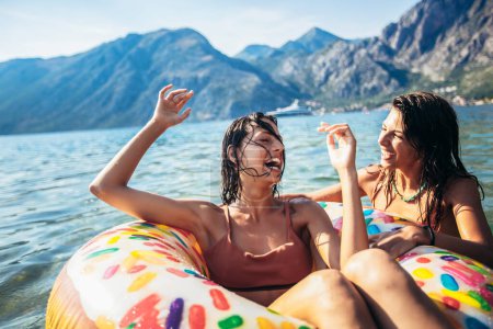 Téléchargez les photos : Les amis s'amusent pendant leurs vacances d'été.Groupe d'amis nageant et s'amusant à la mer. - en image libre de droit