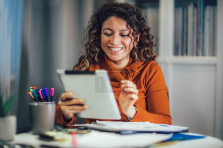 Téléchargez les photos : Femme d'affaires travaillant sur tablette numérique à la maison lors d'une vidéoconférence avec un partenaire d'affaires. - en image libre de droit
