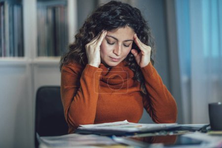 Photo for Young woman suffer from headache work on laptop at home office. - Royalty Free Image