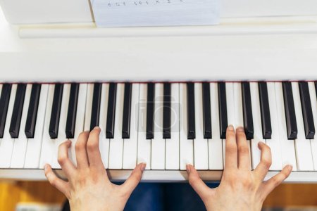 Photo for Child practicing on the modern electric piano at home. Music lesson. Close-up. - Royalty Free Image
