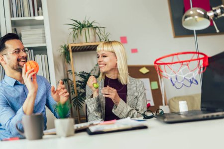 Téléchargez les photos : Portrait de jeunes gens d'affaires travaillant ensemble au bureau à domicile s'amusant avec le basket-ball. Concept de démarrage du travail d'équipe en couple - en image libre de droit