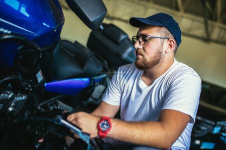 Téléchargez les photos : Mécanicien de moto professionnel travaillant dans le service de réparation de vélos - en image libre de droit