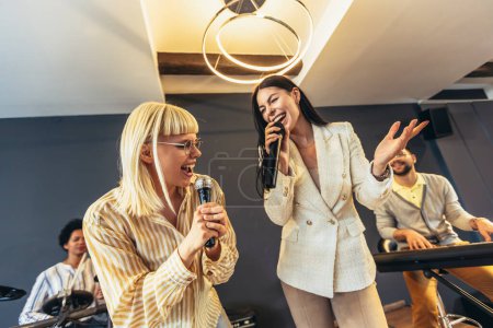 Foto de Gente de negocios haciendo ejercicio de entrenamiento de equipo durante seminario de team building cantando karaoke
. - Imagen libre de derechos
