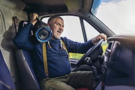 Téléchargez les photos : Conducteur professionnel conduisant un camion sur la route écouter de la musique et s'amuser. - en image libre de droit