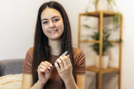 Foto de Women's nails and nail file. Self-manicure at home for yourself. - Imagen libre de derechos