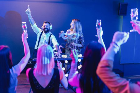 Téléchargez les photos : Groupe de personnes dansant dans le club avec DJ en arrière-plan - en image libre de droit