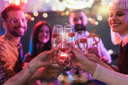Téléchargez les photos : Groupe d'amis faisant la fête dans une boîte de nuit et trinquant à des boissons
. - en image libre de droit
