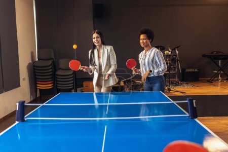 Téléchargez les photos : Les jeunes jouent au tennis de table au bureau au travail - en image libre de droit