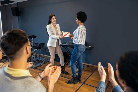 Téléchargez les photos : Femme d'affaires reçoit un prix devant les professionnels des affaires, applaudissant lors d'un séminaire d'affaires dans un immeuble de bureaux - en image libre de droit