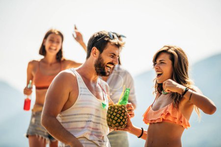 Téléchargez les photos : De jeunes amis s'amusent à la plage par une journée ensoleillée. - en image libre de droit