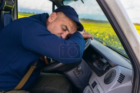 Foto de Conductor de camión agotado durmiendo en el volante. Cansancio y concepto del sueño. - Imagen libre de derechos