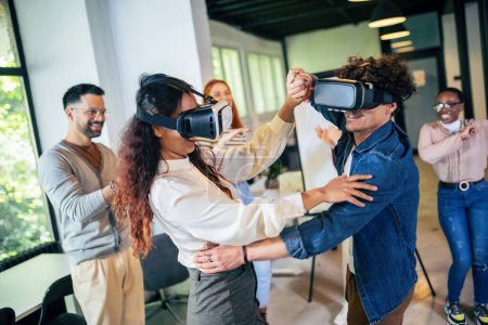 Téléchargez les photos : Travailleurs multiethniques qui s'amusent dans leur travail au bureau en portant des lunettes VR - en image libre de droit