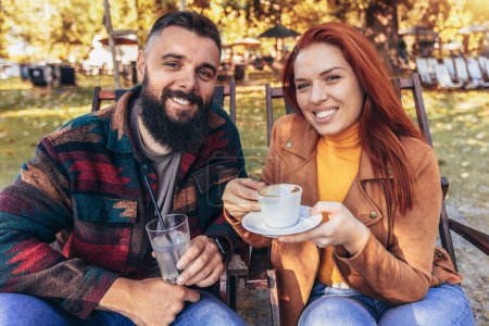 Photo for Beautiful loving couple sitting in a cafe enjoying in coffee and conversation. - Royalty Free Image