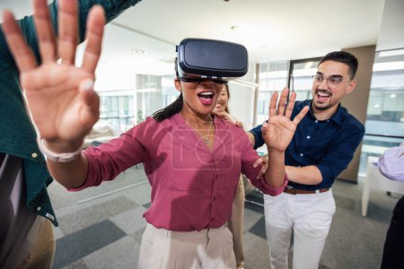 Téléchargez les photos : Groupe de professionnels jouant avec des lunettes VR sur le travail dans le bureau moderne.Team Building - en image libre de droit