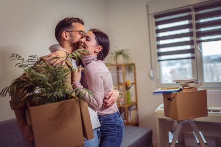 Téléchargez les photos : Smiling couple unpacking boxes in new home.New life. - en image libre de droit