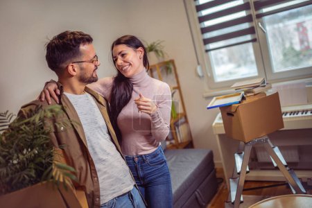 Photo for Smiling couple unpacking boxes in new home.New life. - Royalty Free Image