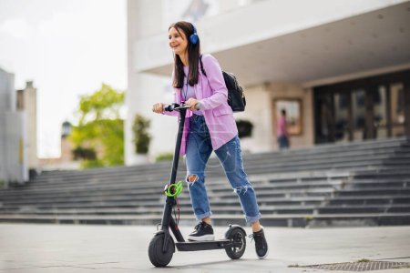 Téléchargez les photos : Étudiant heureux sur scooter à l'extérieur sur l'air frais - en image libre de droit