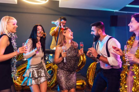 Photo for Group of people dancing in the club celebrating New Years - Royalty Free Image