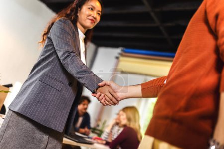 Photo for Businessman and businesswoman celebrating success by doing handshake in office - Royalty Free Image