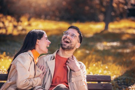 Téléchargez les photos : Jeune couple étreignant et s'amusant dans un parc - en image libre de droit
