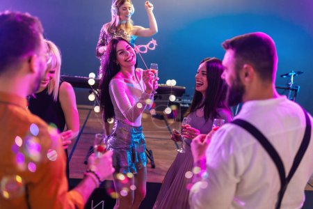 Téléchargez les photos : Groupe de jeunes belles personnes faisant la fête au club. Célébration et consommation d'alcool - en image libre de droit