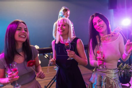 Photo for Beautiful young girls having fun at the club and drinking alcohol - Royalty Free Image