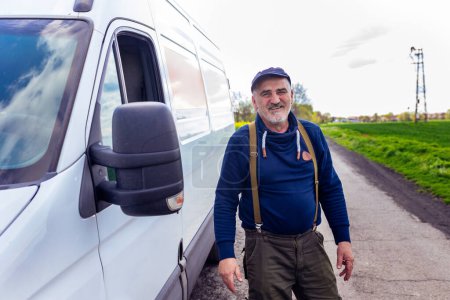 Photo for Happy confident male driver standing in front on his van and looking at camera. - Royalty Free Image