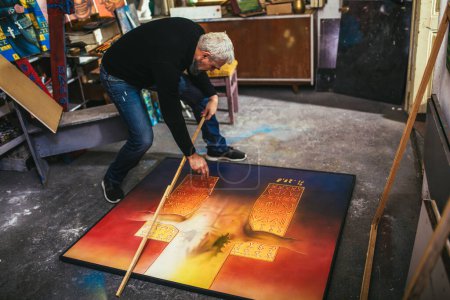 Téléchargez les photos : Mature homme peinture sur toile en atelier d'art
. - en image libre de droit