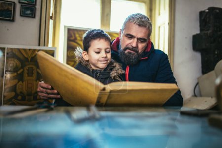 Photo for Father and son reading a book together - Royalty Free Image