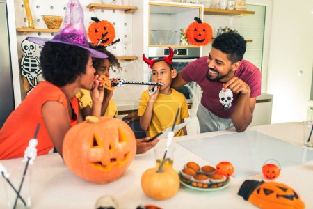 Téléchargez les photos : La famille s'amuse à Halloween passer un appel vidéo avec une tablette numérique. - en image libre de droit