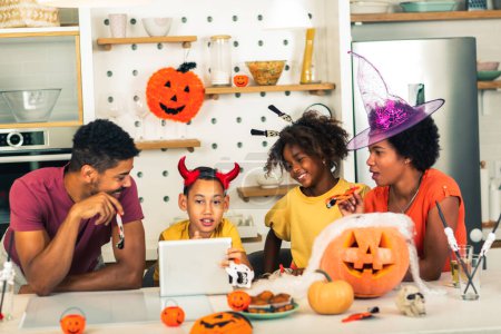 Foto de Familia se divierte en tiempo de Halloween hacer videollamada con tableta digital. - Imagen libre de derechos