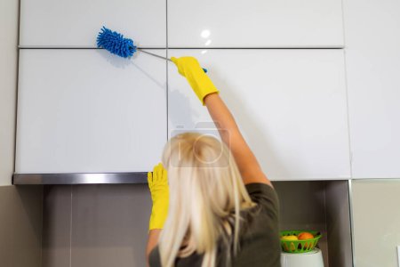 Téléchargez les photos : Jeune femme blonde nettoyer la cuisine - en image libre de droit