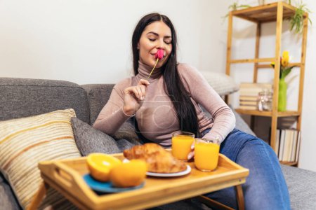 Téléchargez les photos : Beautiful woman drinking orange juice at home. Healthy lifestyle concept. - en image libre de droit