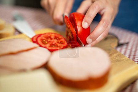 Foto de Haciendo un sándwich. Cortar comestibles con cuchillo. Difusión - Imagen libre de derechos