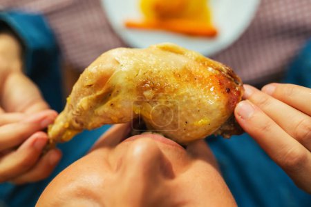 Téléchargez les photos : Gros plan de la femme mangeant une cuisse de poulet - en image libre de droit