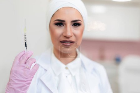Foto de Retrato de una enfermera con jeringa de medicamento en la mano. - Imagen libre de derechos