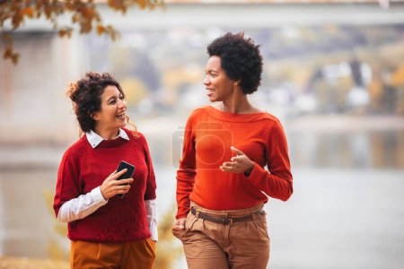 Photo for Two happy female friends walking outside - Royalty Free Image