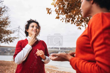 Photo for Female friends deaf talking with nonverbal communication outdoor. - Royalty Free Image