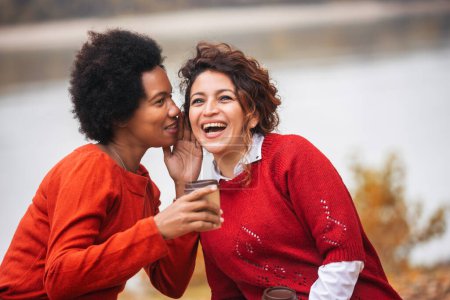 Photo for Two happy female friend talking and sharing life stories, enjoying autumn outdoors , drinks coffee. Women's friendship - Royalty Free Image