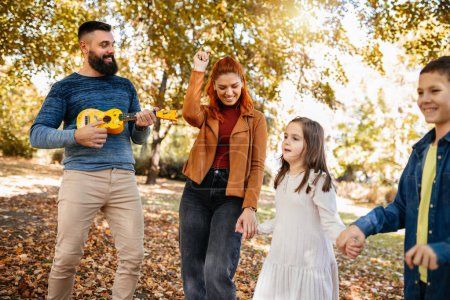 Foto de Familia feliz caminando en el parque en un día soleado de otoño. Parque colorido. - Imagen libre de derechos