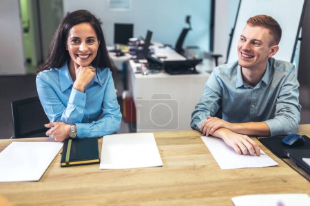 Photo for Office colleagues having discussion during meeting in conference room. Group of men and women sitting in conference room and smiling. - Royalty Free Image