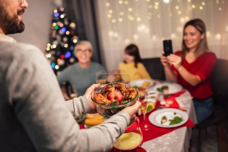 Téléchargez les photos : Bonne famille multi-générations profiter d'un déjeuner ensemble à la maison. Famille le dîner de Noël à la maison - en image libre de droit