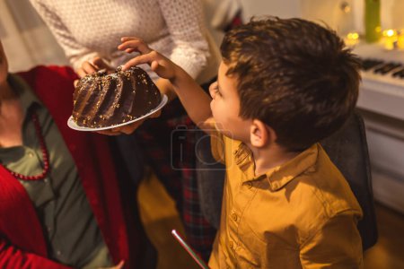 Foto de Mamá trajo un delicioso pastel en la mesa del comedor. Familia celebrando la Navidad. - Imagen libre de derechos