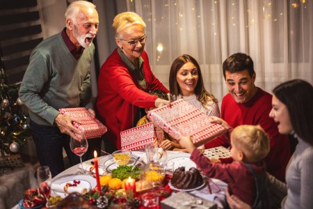 Téléchargez les photos : Les grands-parents ont apporté des cadeaux pour leur famille à Noël. - en image libre de droit